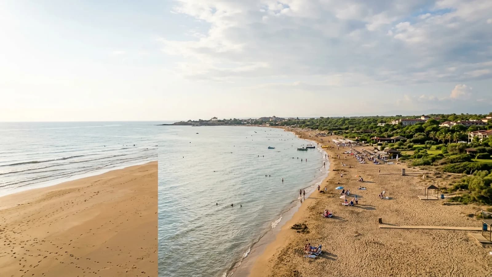Kumkoy, Türkiye — the wide sandy beach at Kumkoy west of Side, calm shallow sea and a flat green coastal strip behind the shore.