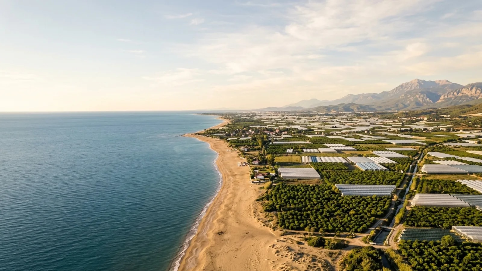 Kizilagac, Türkiye — the coastal plain at Kizilagac east of Side, a sandy beach and farmland of greenhouses and citrus groves behind it.